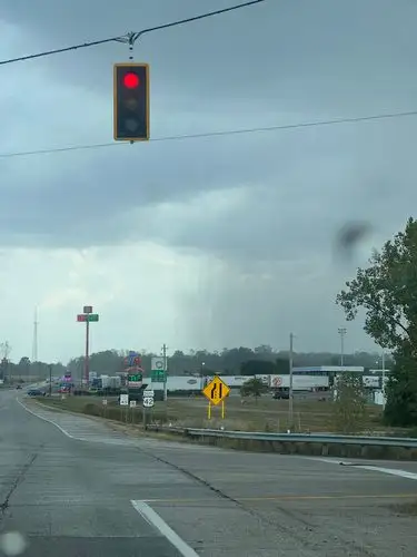 Red light, gray sky, and a shower in the distance.